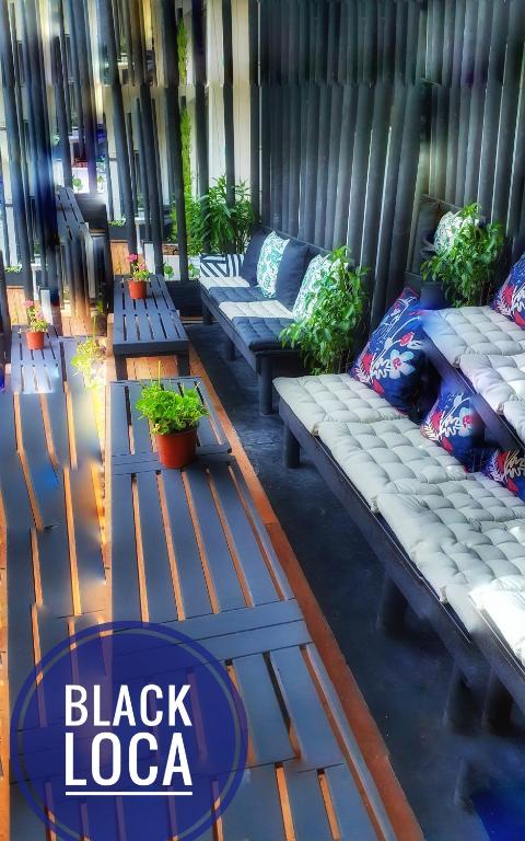 a group of benches sitting on a porch with plants at The D Hotel Çeşme Resort in Çeşme