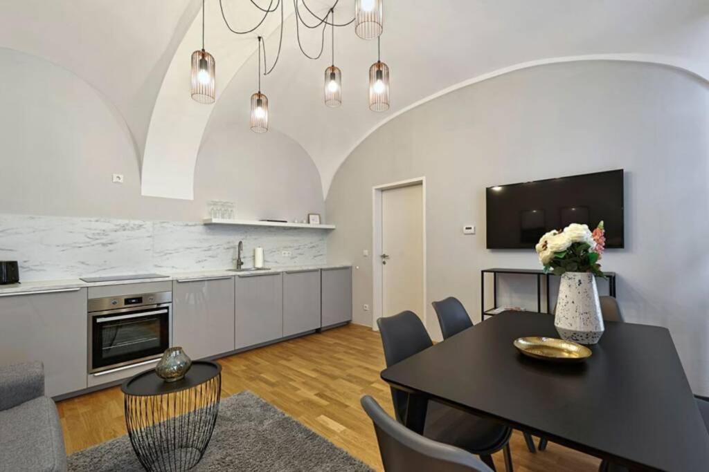 eine Küche und ein Esszimmer mit einem schwarzen Tisch und Stühlen in der Unterkunft Vienne City Apartment Crown 6 in Wien