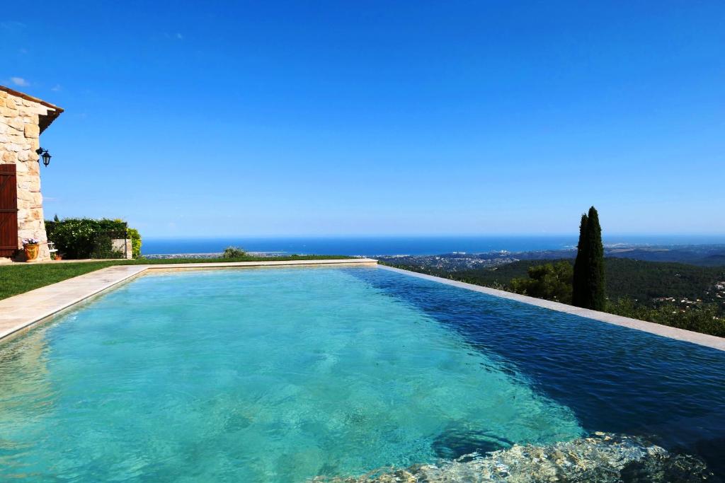 a swimming pool with a view of the ocean at La Bastide des Pins in Vence