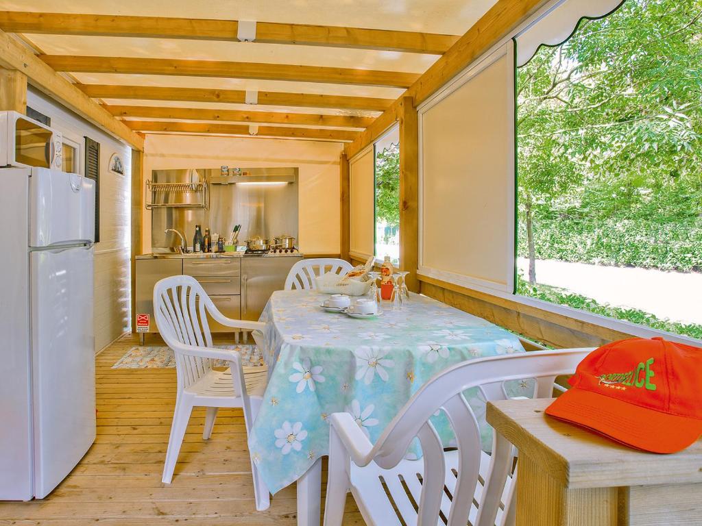 a dining room with a table and a refrigerator at Portofelice Camping Village in Eraclea Mare