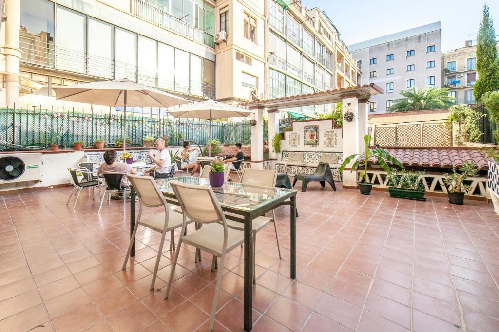 a restaurant with tables, chairs, tables and umbrellas at Fabrizzios Terrace Hostel in Barcelona