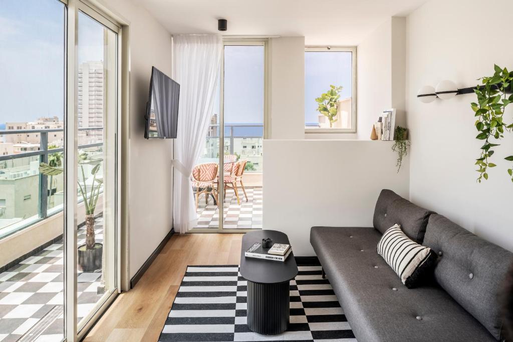 ein Wohnzimmer mit einem Sofa und einem Balkon in der Unterkunft Mr. Montana - By TLV2GO in Tel Aviv