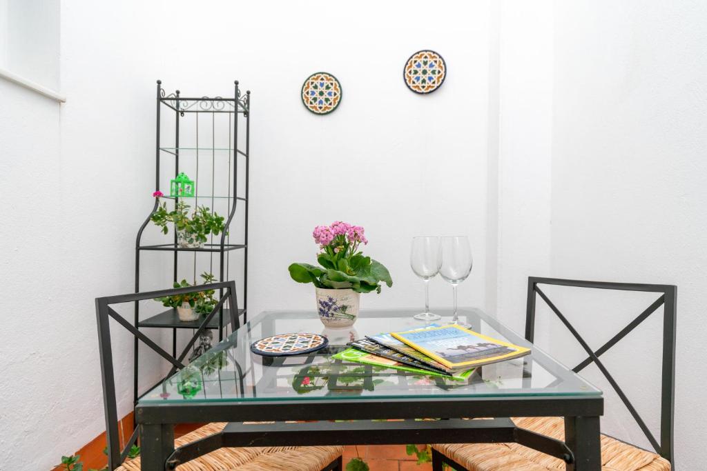 ein Glastisch mit Blumen und Gläsern darauf in der Unterkunft Anna Triana Boutique Apartament in Sevilla