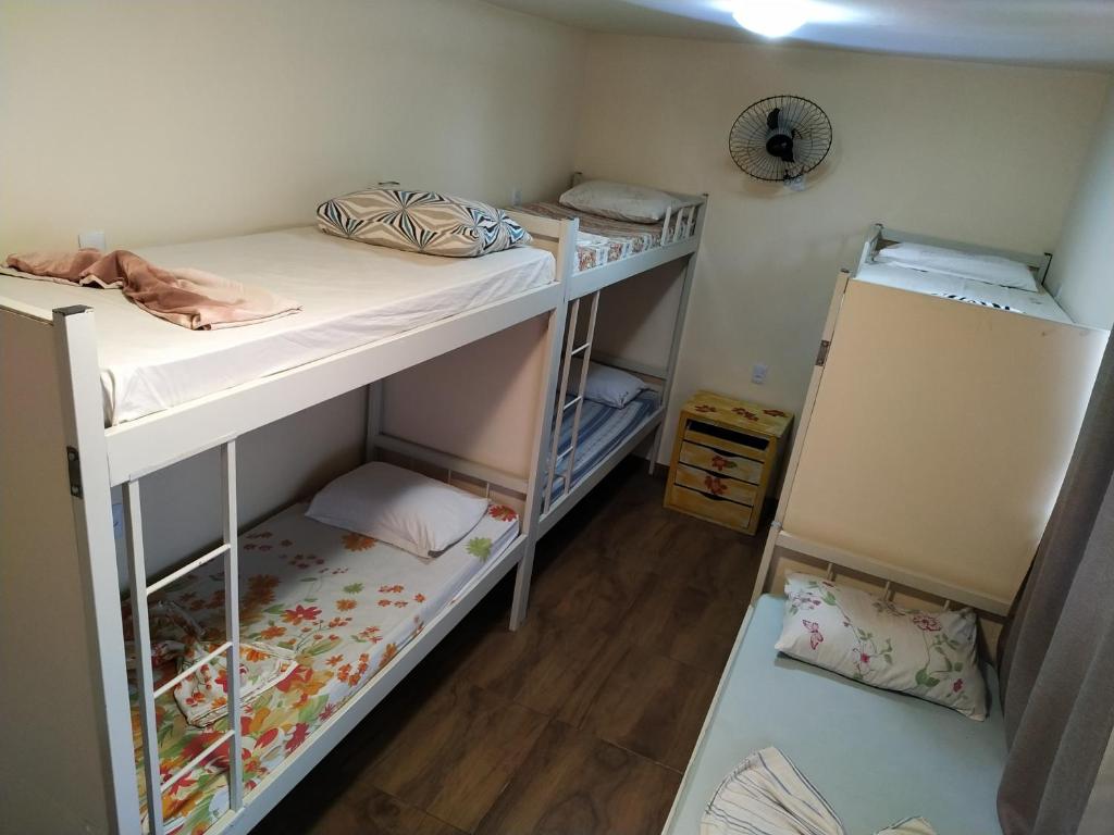 Hostel BH في بيلو هوريزونتي: سريرين بطابقين في غرفة مع أرضيات خشبية