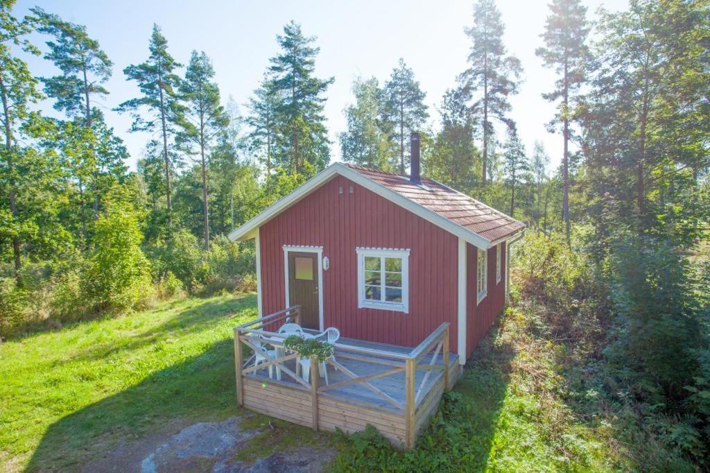 a red tiny house in the middle of a field at Maren 2 in Mörlunda