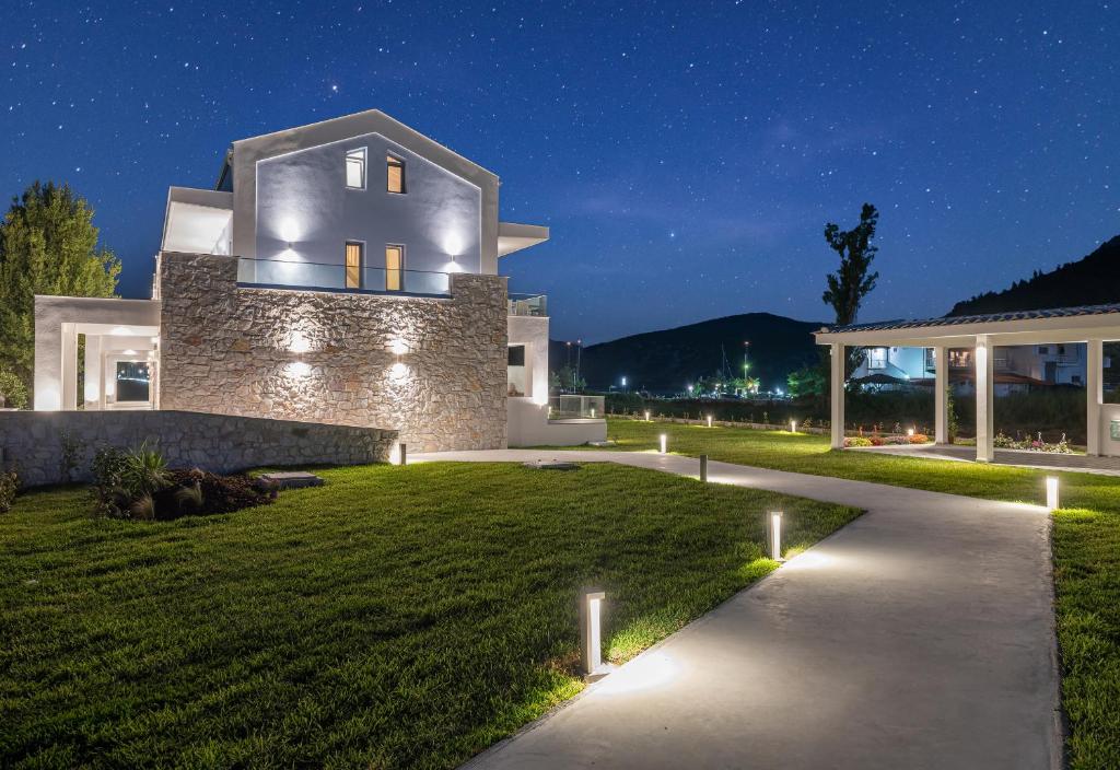 a house with lights on the lawn at night at Notia Luxury Living in Porto Koufo