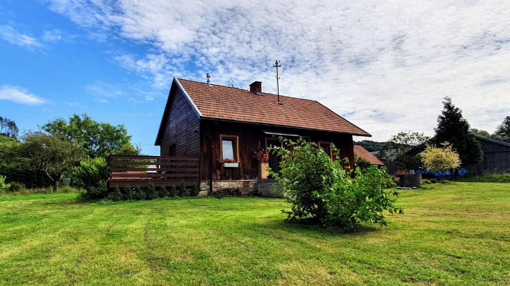 a small house on a grassy field with a sky at Wieś odNowa in Łabowa
