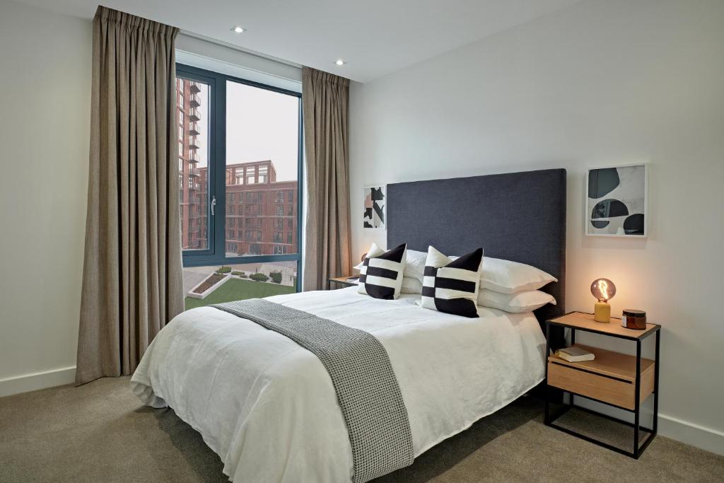 a bedroom with a large bed and a large window at Manchester Media City by Charles Hope in Manchester