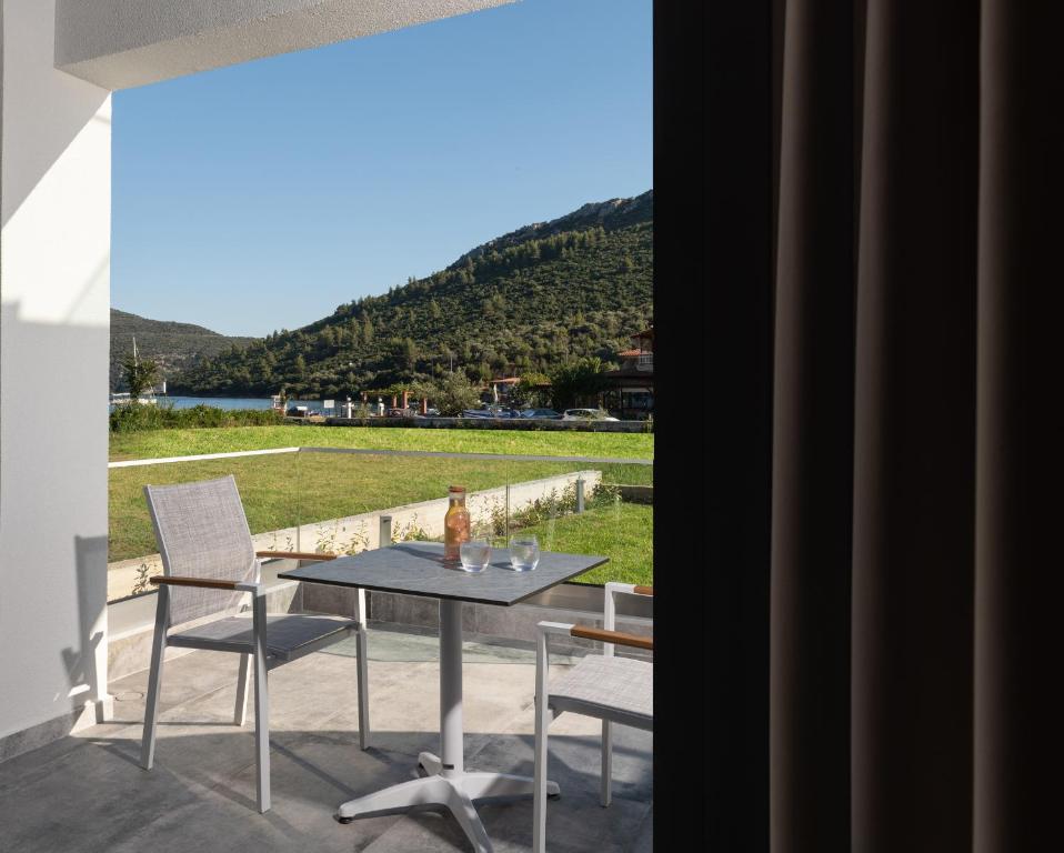 a table and chairs on a patio with a view of a field at Notia Luxury Living in Porto Koufo