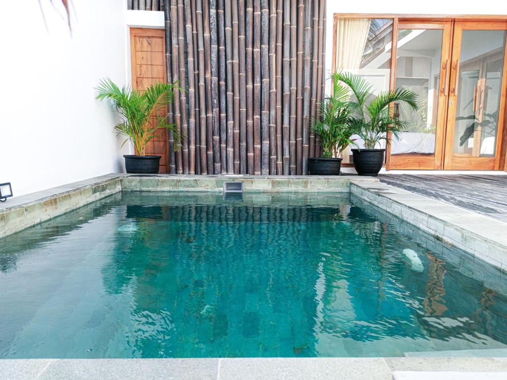 een zwembad met blauw water voor een huis bij Watukarung Prapto Homestay in Kalak