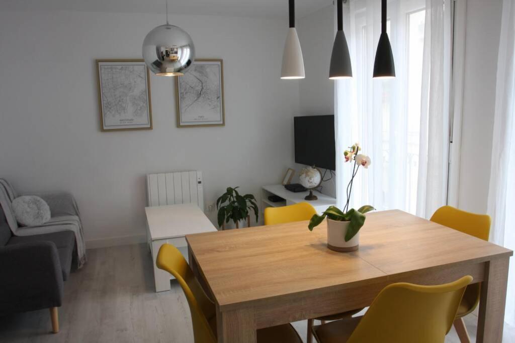 ein Esszimmer mit einem Holztisch und gelben Stühlen in der Unterkunft Apartamentos La Herradura Balcón in Haro