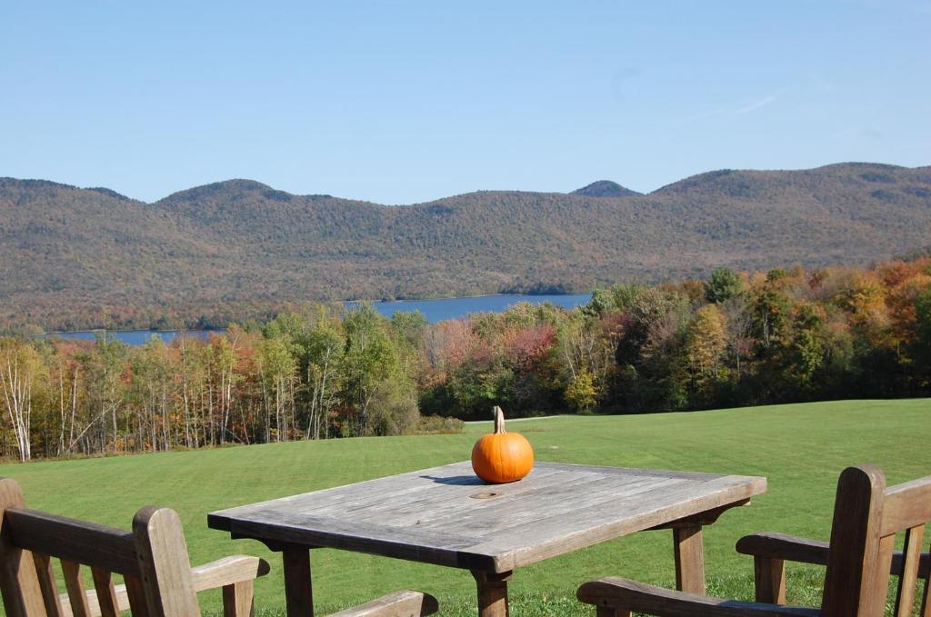 a pumpkin sitting on a wooden table on a field at The Mountain Top Inn & Resort in Chittenden