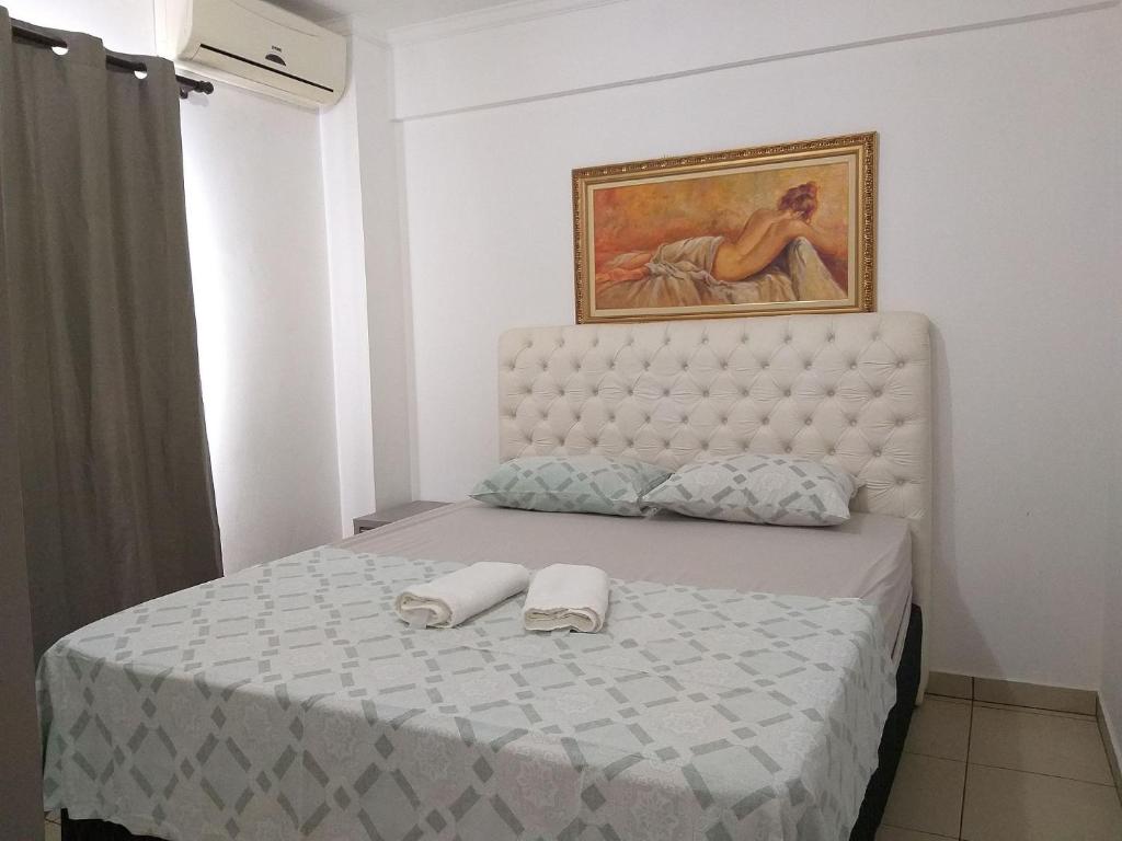 een slaapkamer met een bed met twee handdoeken erop bij Apartamento Cidade Verde 6 MT in Maringá