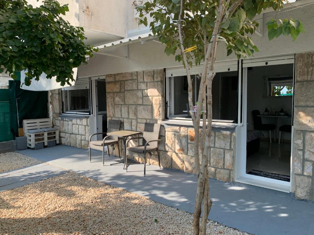 a patio with chairs and a table next to a building at Studio apartman Miko in Imotski