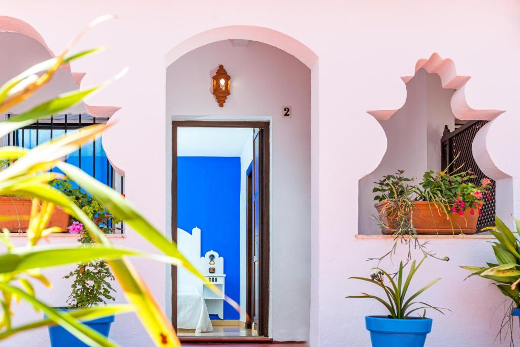 a hallway with plants in front of a doorway at Hostal Alhambra in Zahora