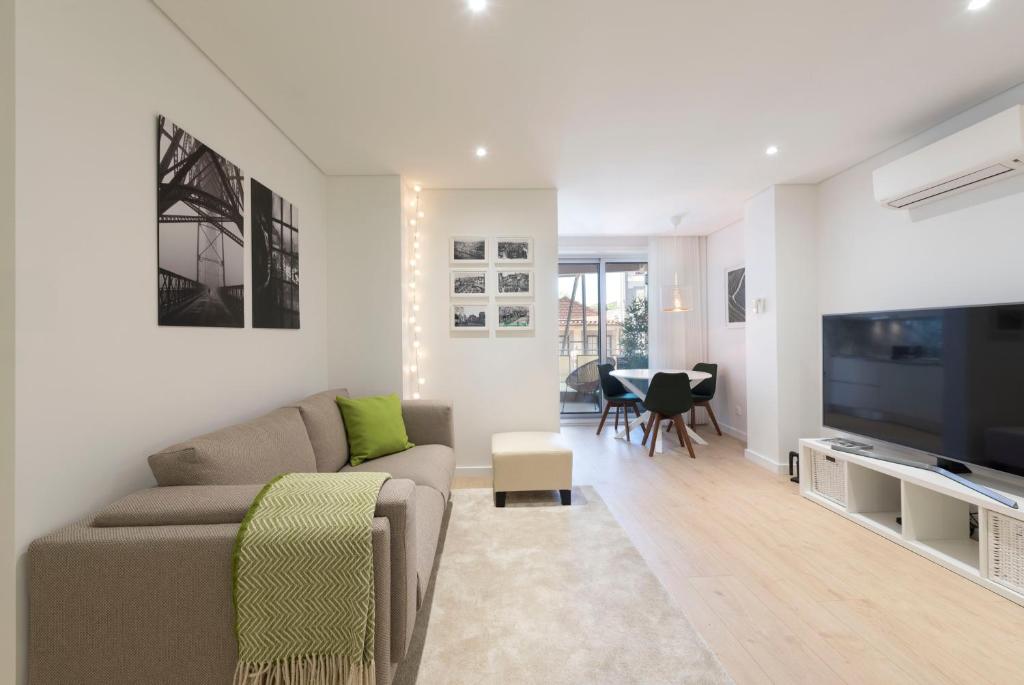 a living room with a couch and a tv at Heart of D. Pedro Apartments III in Porto