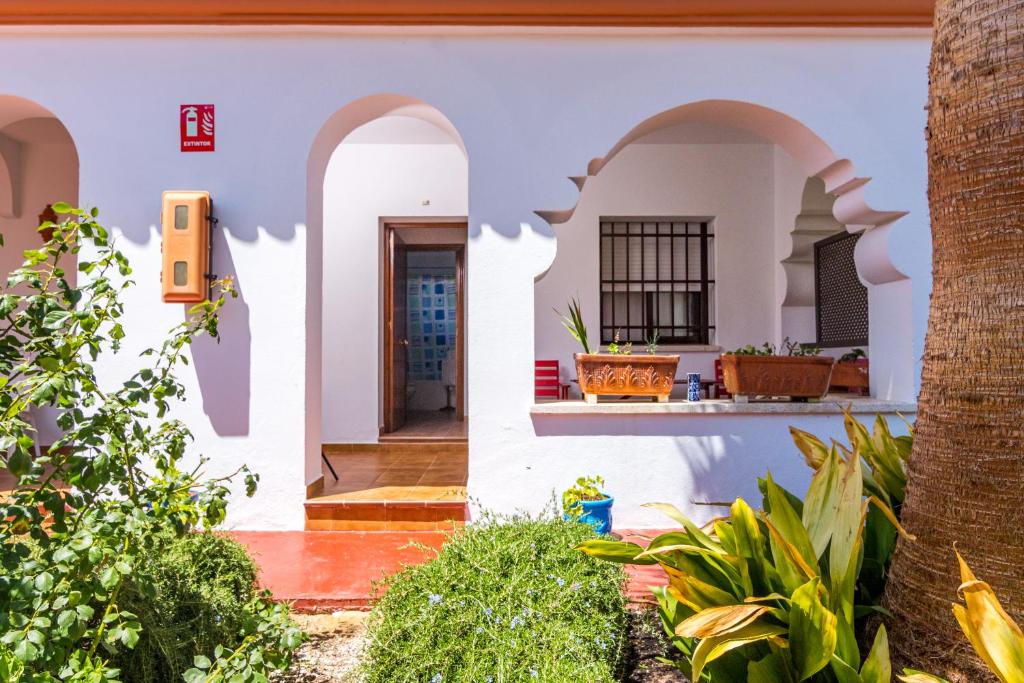 a home with white walls and arches at Hostal Alhambra in Zahora
