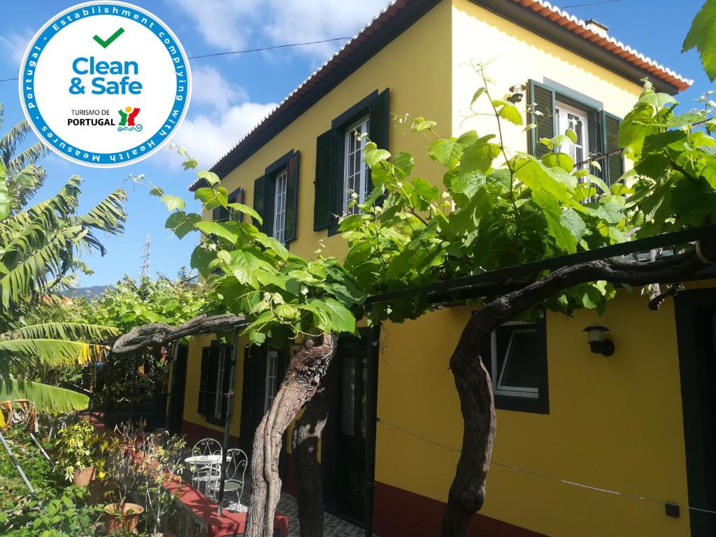 een geel huis met een boom ervoor bij Casa D`Avó Celina in Funchal