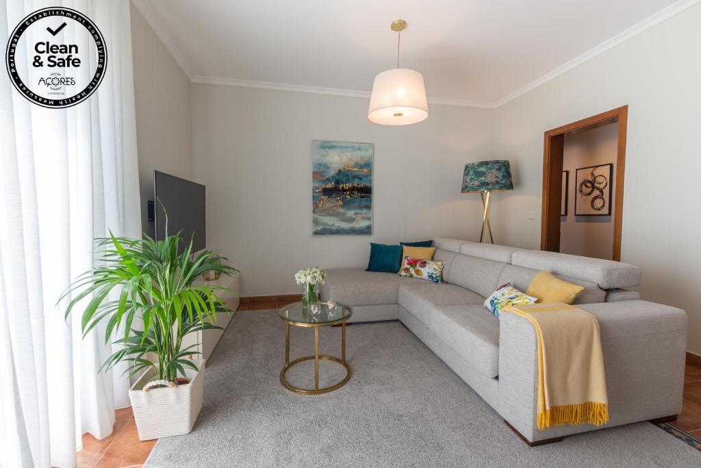 ein Wohnzimmer mit einem Sofa und einem Tisch in der Unterkunft Terrace Apartment in Ponta Delgada