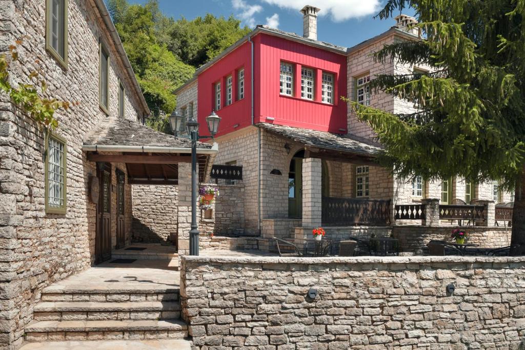 ein rotes Gebäude auf einem Steingebäude in der Unterkunft Ameliko Zagori in Ano Pedina