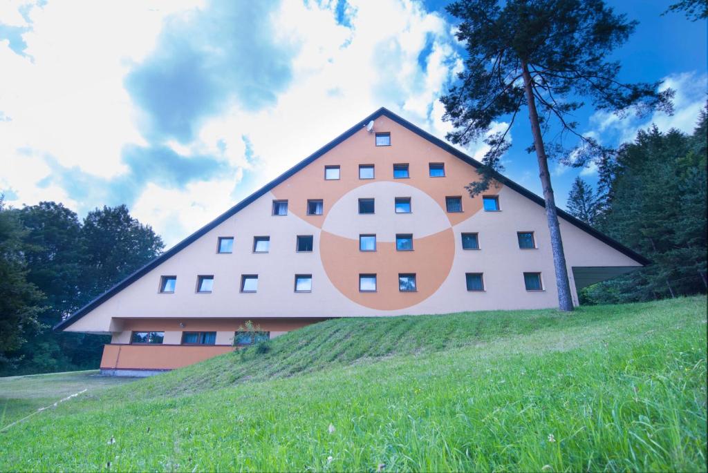 een groot huis bovenop een grasheuvel bij HOTEL SVRATKA in Svratka