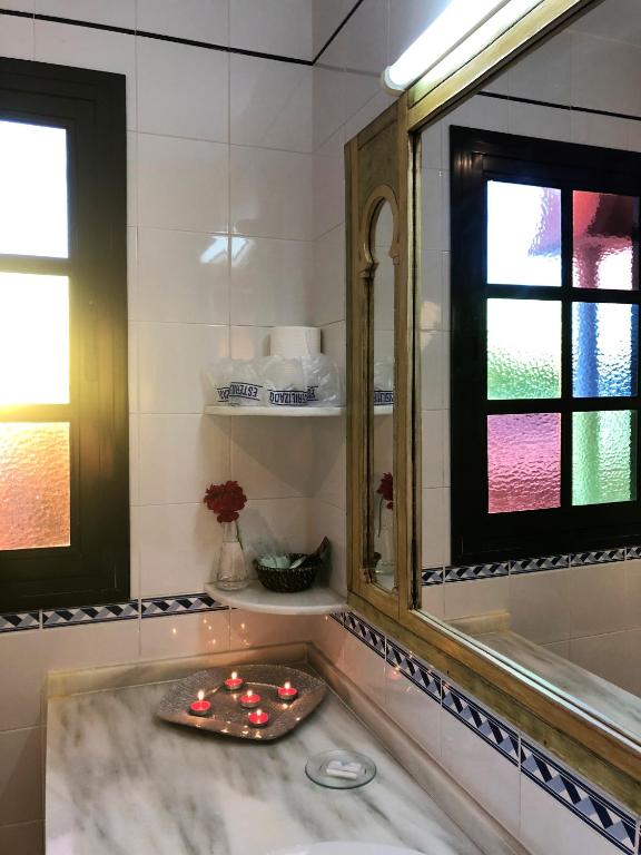 a bathroom with a large mirror and a sink at Hostal Alhambra in Zahora