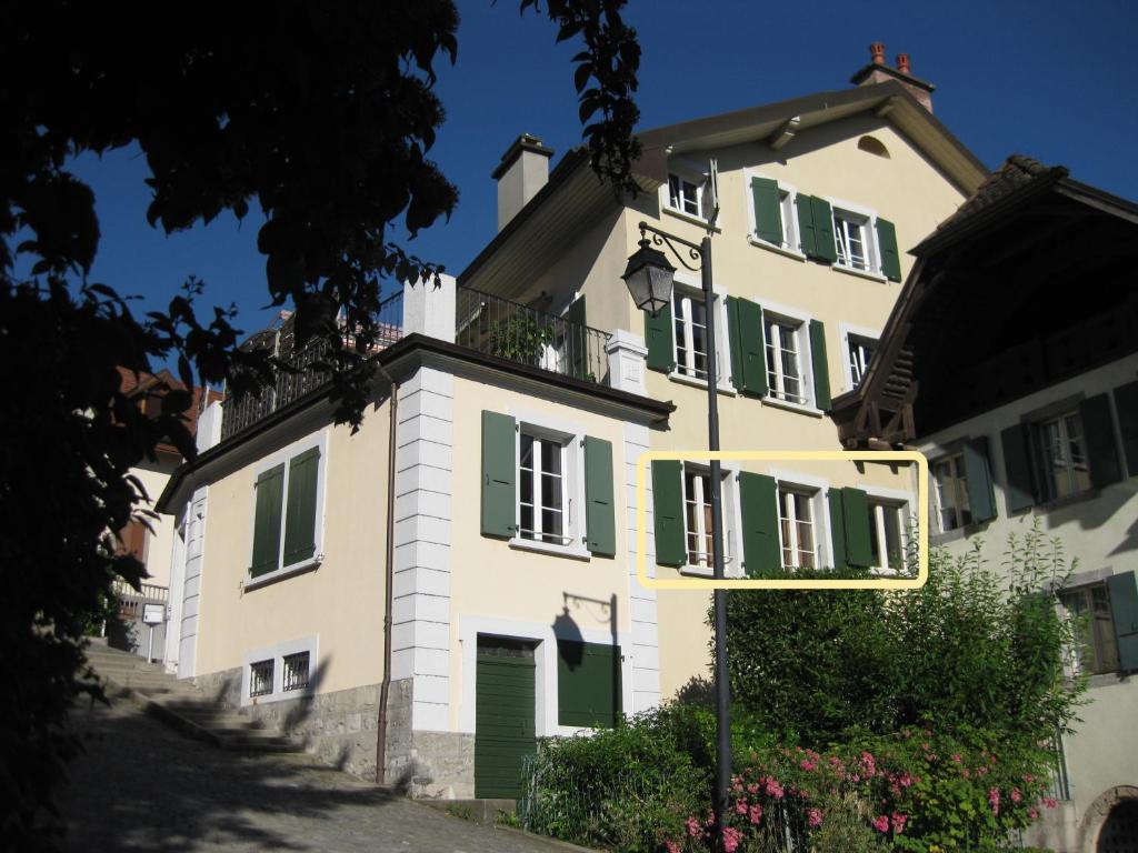un grande edificio bianco con finestre con persiane verdi di Apartment Montreux center 5 min from the lake a Montreux