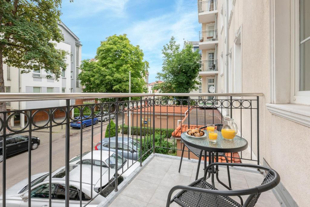 a balcony with a table and chairs and a street at Blue Mandarin Apartments II in Sopot