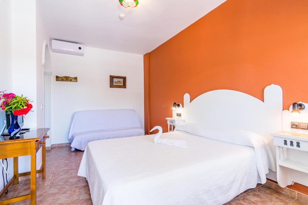 a hospital room with two beds and a table at Hostal Alhambra in Zahora