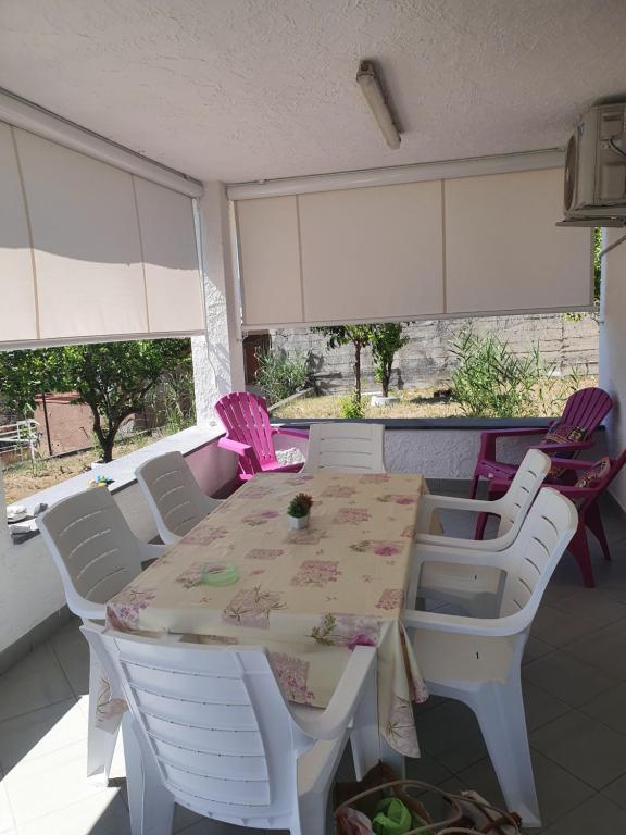 un tavolo bianco con sedie in una stanza con finestre di Palinuro Villa Bellavista a Palinuro
