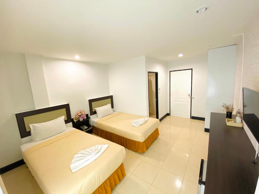 a hotel room with two beds and a bathroom at Polkadot Hostel in Phitsanulok