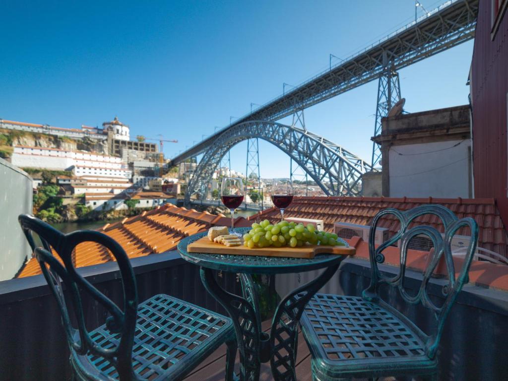 einen Tisch mit einem Teller Essen und zwei Gläsern Wein in der Unterkunft Ponte D Luis I Apartments in Porto