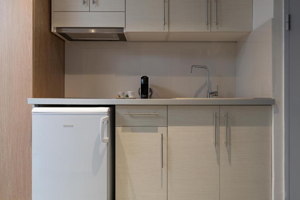 a kitchen with white cabinets and a sink at Notia Luxury Living in Porto Koufo