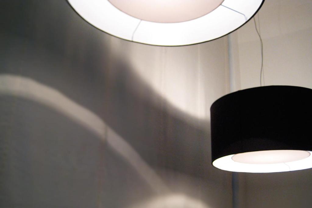 a black and white light fixture and a mirror at Hotel Salus in Pescara