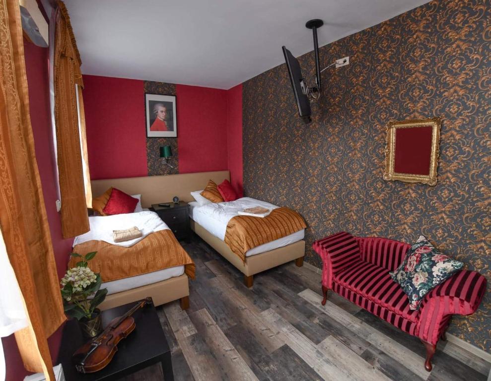 VasszécsenyにあるStőger Panzióのベッド2台と椅子が備わる客室です。