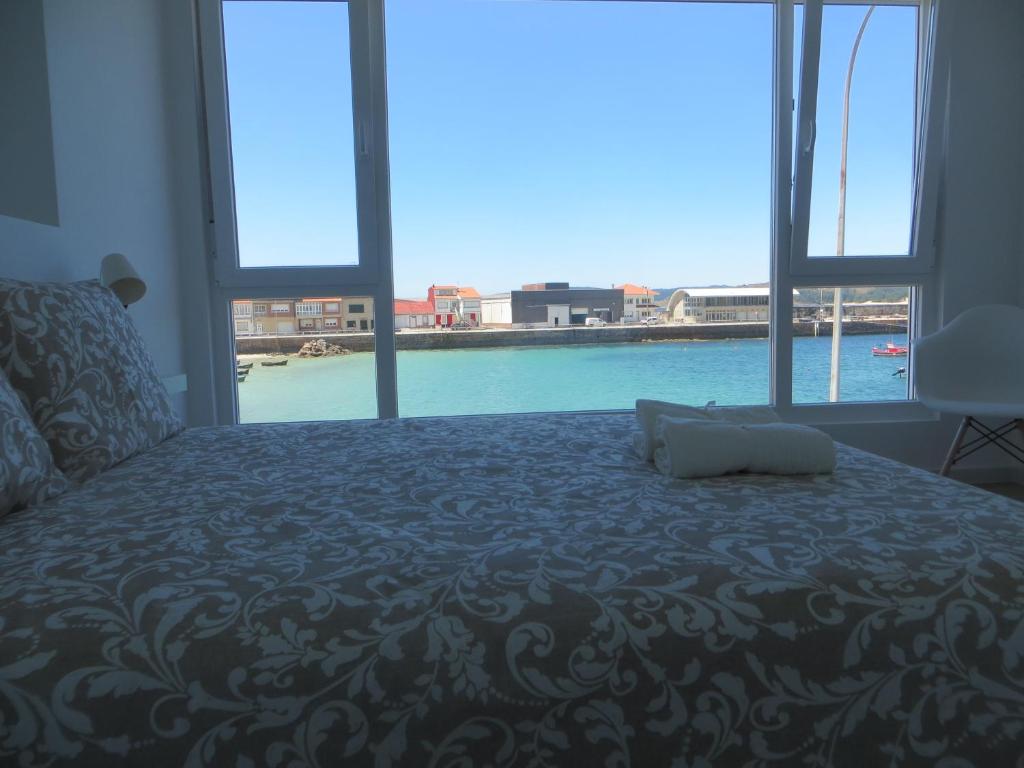 - une chambre avec un lit et une vue sur l'eau dans l'établissement Apartamento Na Beira Do Mar, à O Pindo