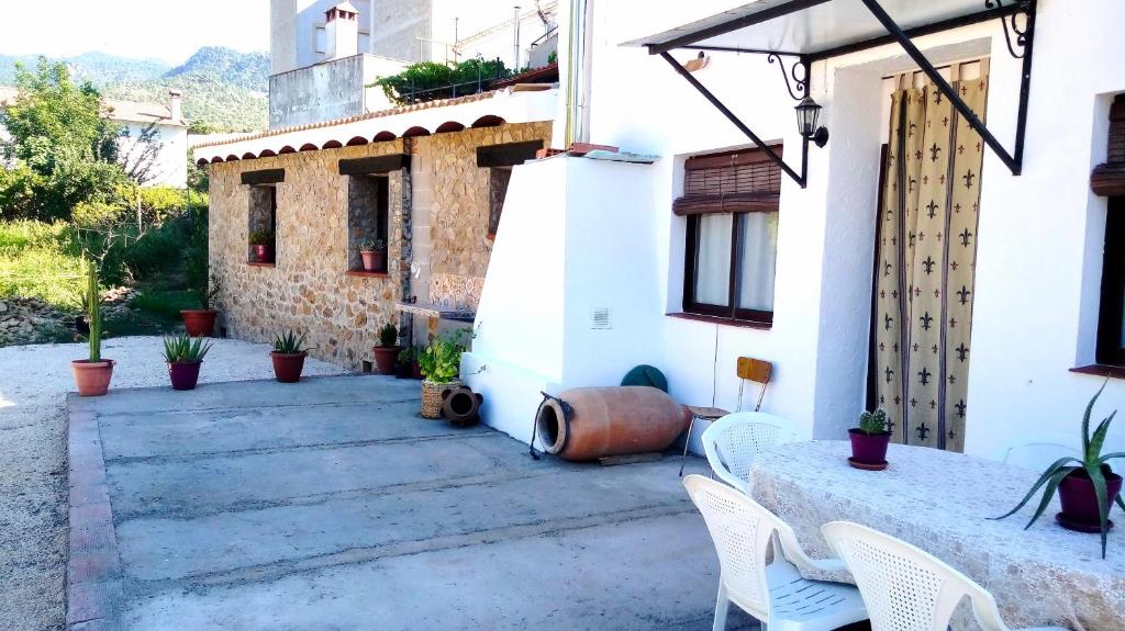 un patio exterior de una casa con mesa y sillas en Casa Rural Los Nietos, en Villaverde de Guadalimar