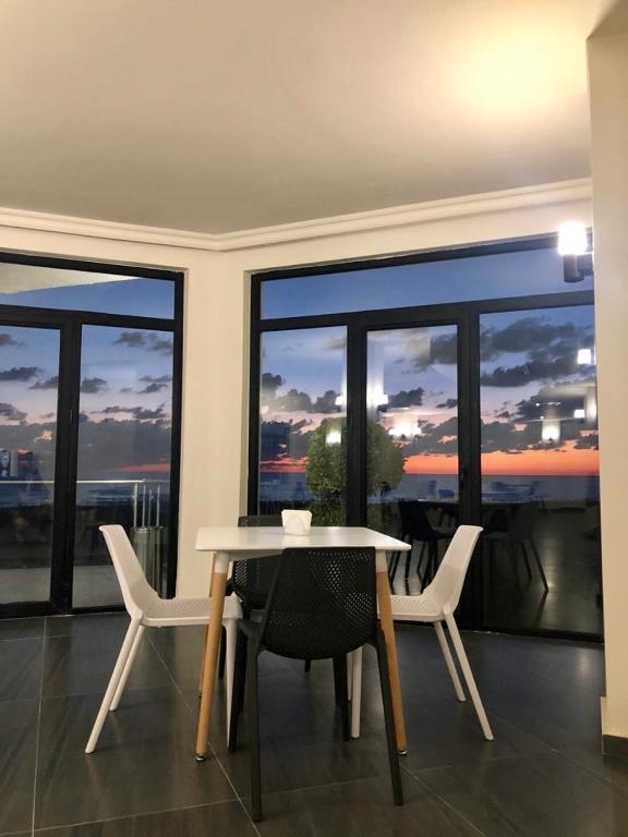 a dining room with a table and chairs and a large window at Hotel Scala in Shekhvetili