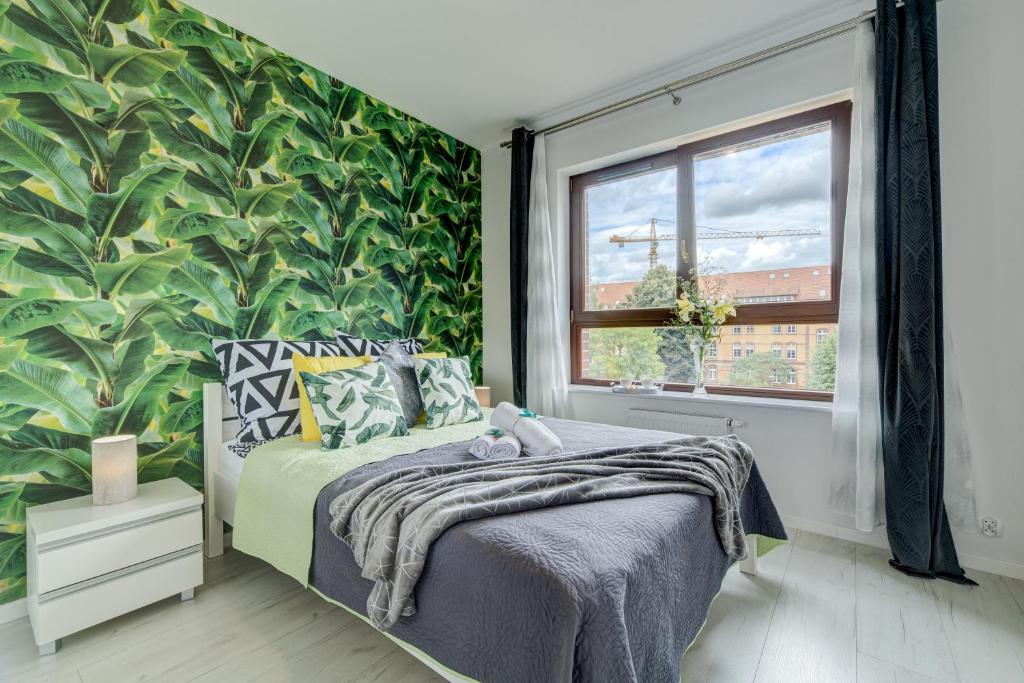een slaapkamer met een bed en een grote groene muur bij Apartamenty Silver 6 in Szczecin