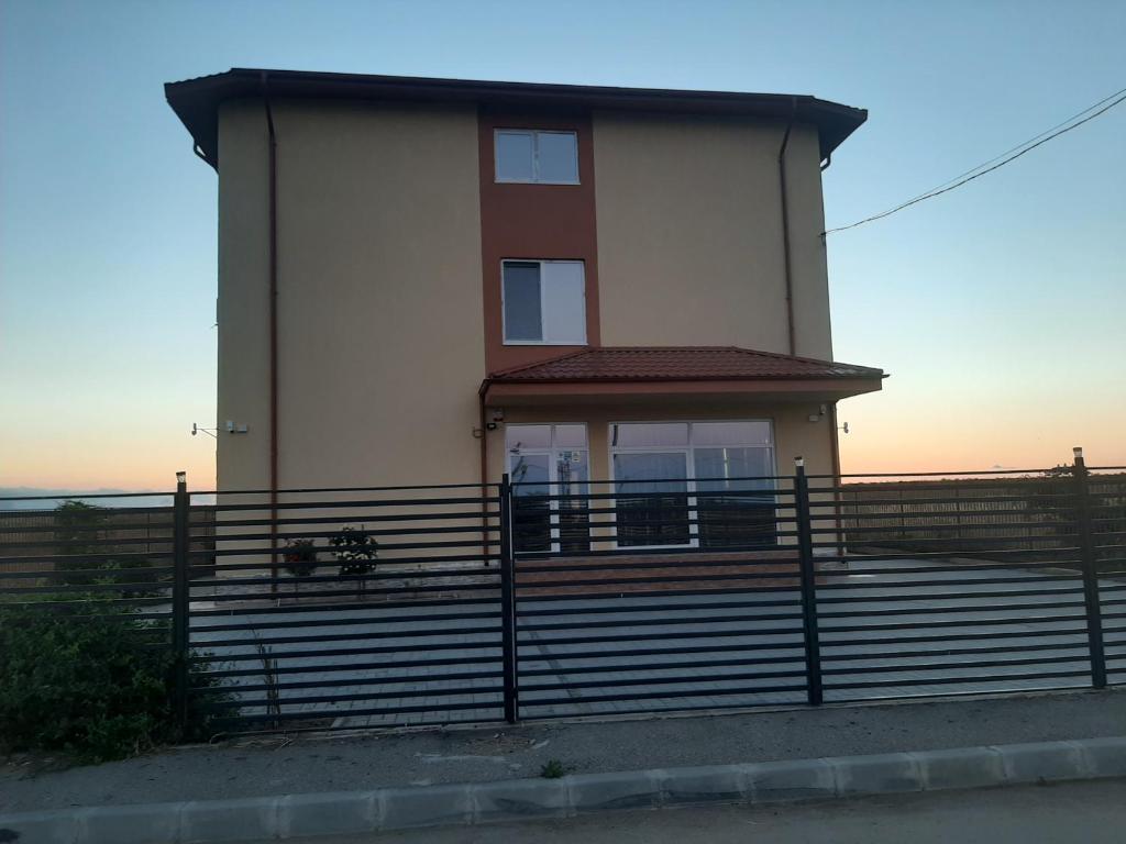 ein Haus mit einem Zaun davor in der Unterkunft Vila Gedar in Costinești