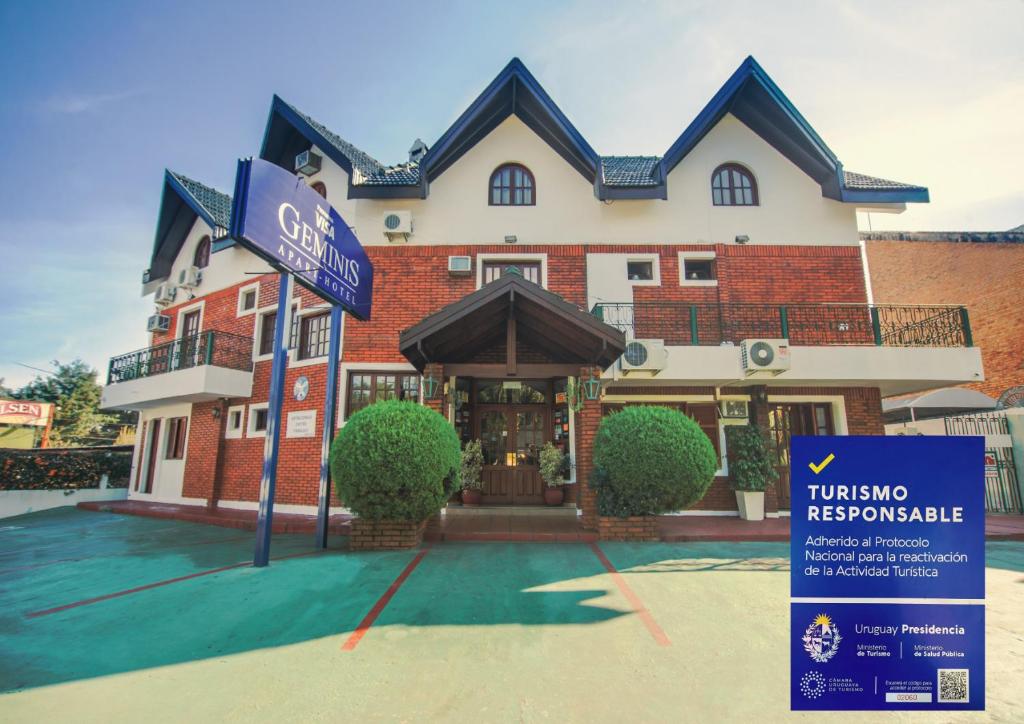 a building with a sign in front of it at Apart Hotel Géminis in Termas del Daymán