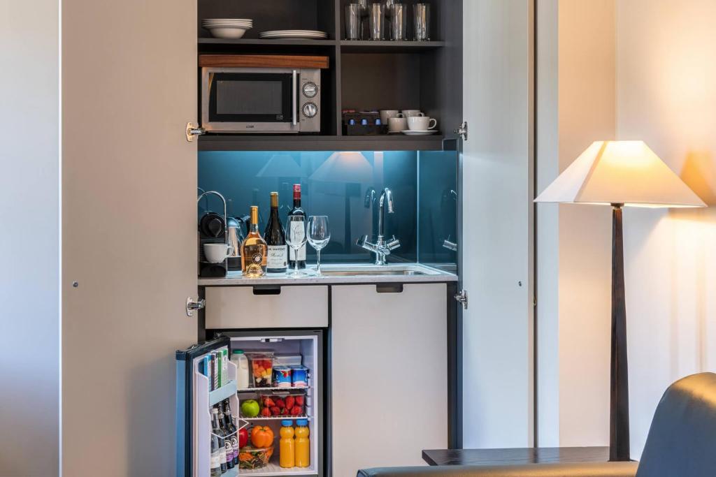 a small kitchen with a sink and a refrigerator at The Resident Soho in London