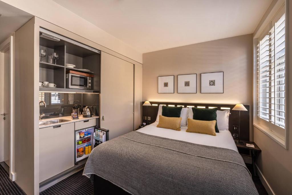 a bedroom with a large bed and a sink at The Resident Soho in London