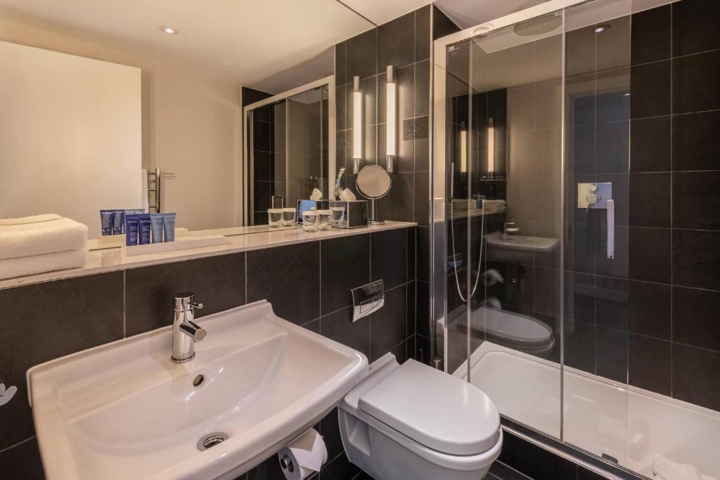 a bathroom with a sink and a toilet and a shower at The Resident Soho in London