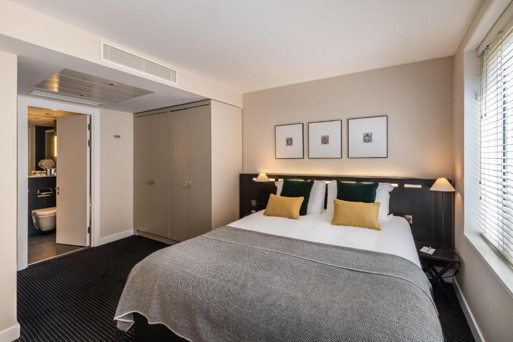 a bedroom with a large bed with yellow pillows at The Resident Soho in London