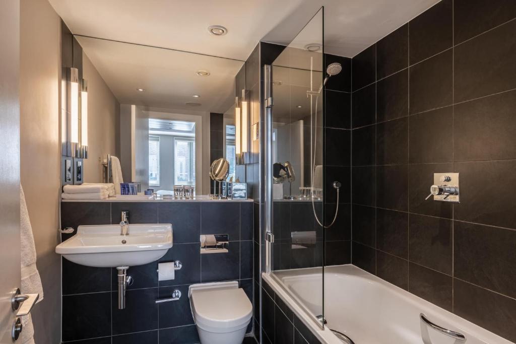 a bathroom with a sink and a toilet and a shower at The Resident Soho in London