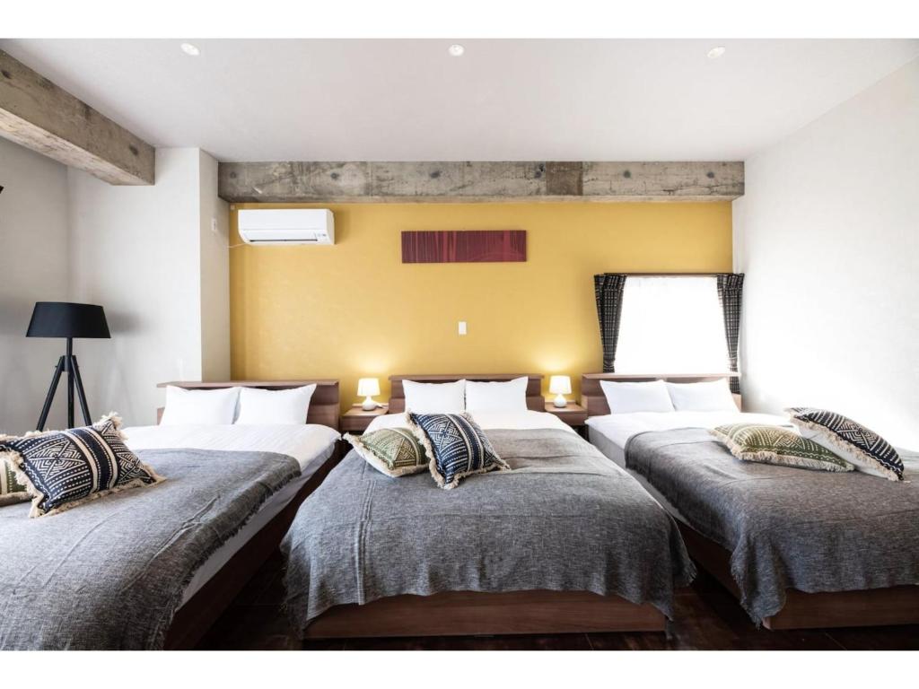 eine Reihe von 4 Betten in einem Zimmer in der Unterkunft Volcano - Vacation STAY 89674 in Kagoshima
