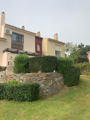 a stone wall in front of a house at Golf Chalet Islantilla in Islantilla