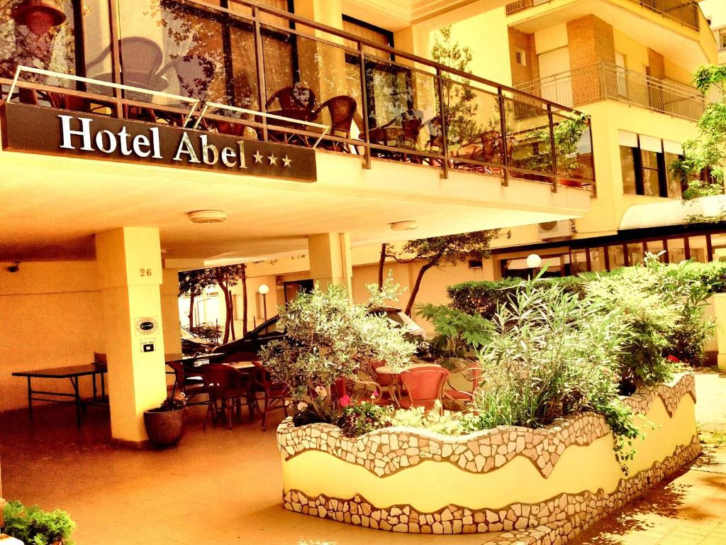 uma área de hotel com uma varanda com plantas e mesas em Hotel Abel & Residence em Cesenatico