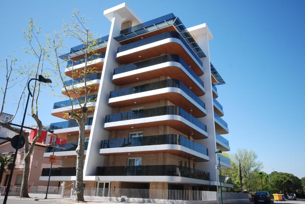 un edificio con balcones al lado de una calle en Residenza Monica, en Lignano Sabbiadoro